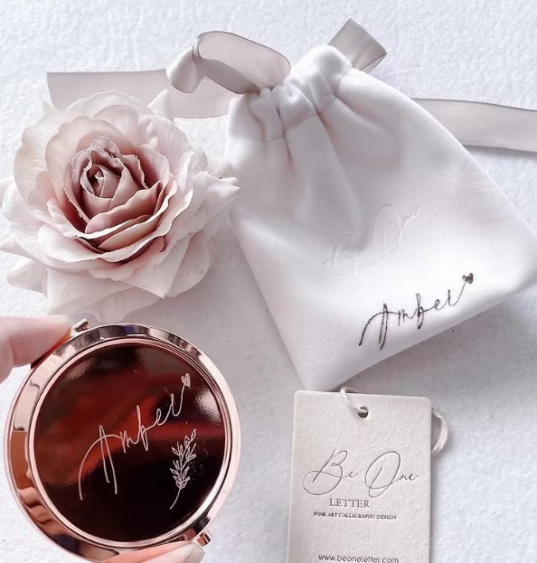 婚禮回禮小禮物推薦7：BE ONE LETTER玫瑰金鏡盒連小絲絨袋 手製西洋書法雕刻 HK$81
