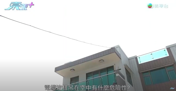 元朗村屋住戶橫跨整個空地駁電線，只為幫電動車充電，影片截圖，來源︰《東張西望》。