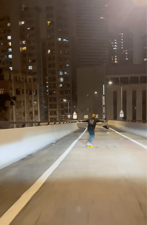 兩男深夜闖山道天橋踩板拍片 急速衝落斜路 網民反應兩極：犯法定過癮？