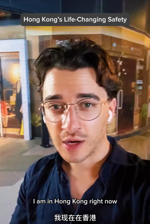 美國遊客深夜獨自街上等車，說香港治安好。（圖片︰網上影片）