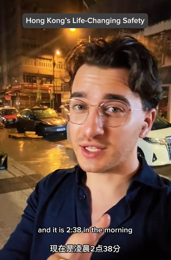 美國遊客深夜獨自街上等車，說香港治安好。（圖片︰網上影片）