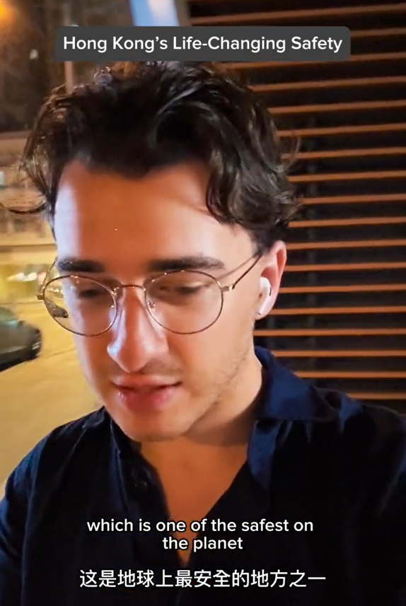 美國遊客深夜獨自街上等車，說香港治安好。（圖片︰網上影片）