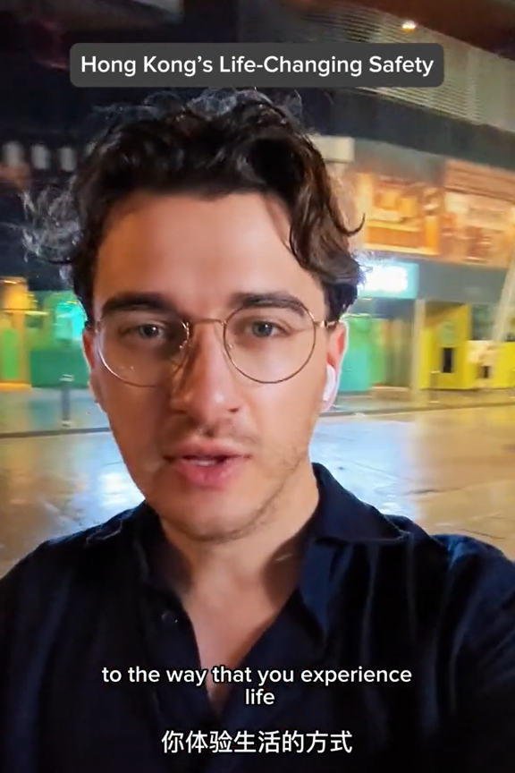 美國遊客深夜獨自街上等車，說香港治安好。（圖片︰網上影片）
