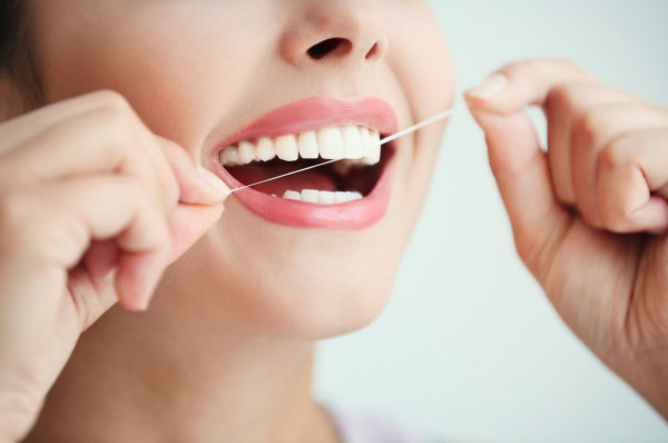 務必養成睡前使用牙線的習慣,以徹底清潔每一顆牙齒的牙縫,預防蛀牙。(圖片來源︰Canva)