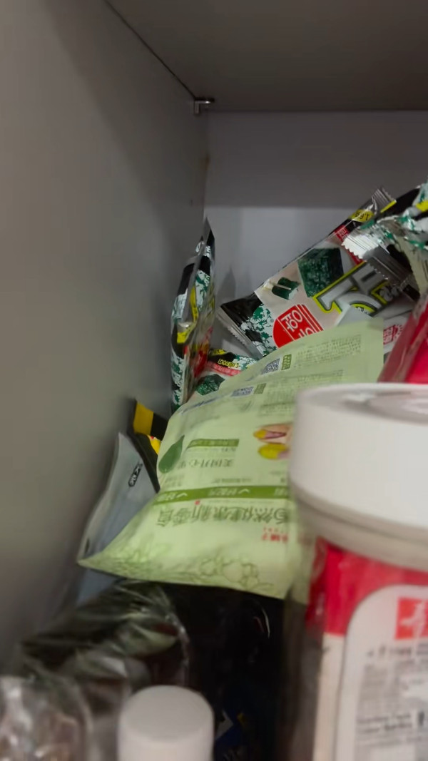 可見港男廚房堆滿拼多多購得的茶葉、垃圾袋、杏仁及飲料，流理台與櫥櫃位置幾乎被塞滿。（截圖：小紅書）