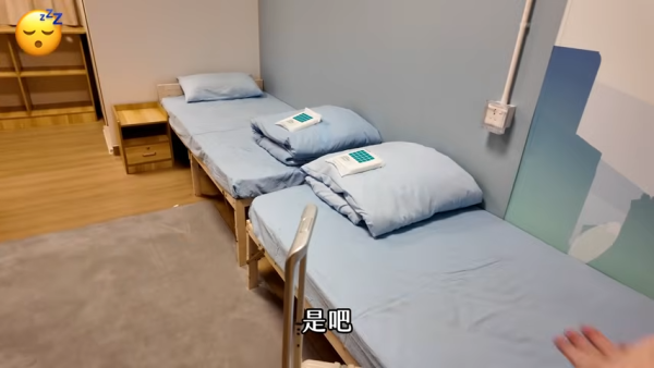 一進門便看到兩張單人床，床上放有即棄毛巾。（截圖：YouTube@天然大年糕）