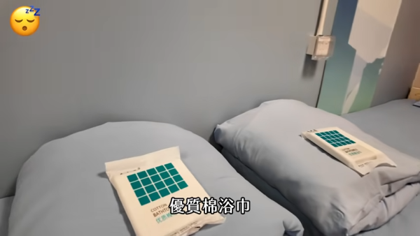 一進門便看到兩張單人床，床上放有即棄毛巾。（截圖：YouTube@天然大年糕）