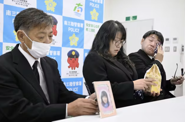 (由左至右)山根名勢的父親友紀、母親千由美和弟弟大也抱著山根名勢的遺體(圖: 日本經濟新聞) (由左至右)山根名勢的父親友紀、母親千由美和弟弟大也抱著山根名勢的遺體(圖: 日本經濟新聞)