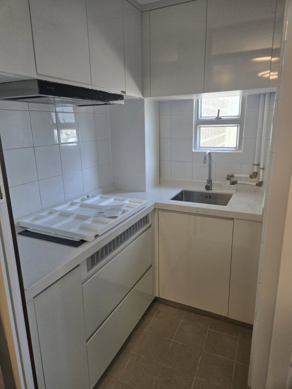 廚房採用全白色L型設計，配備大量組合吊櫃及地櫃，大幅提升儲物空間。（圖片來源：Facebook@香港公營房屋討論區）