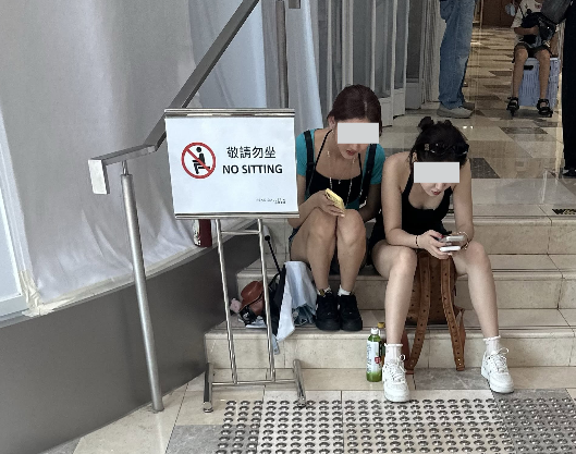 内地游客席地而坐成港铁商铺新常态！“敬请勿坐”告示牌沦为废纸 网友怒喷：完全挡路劝也不走
