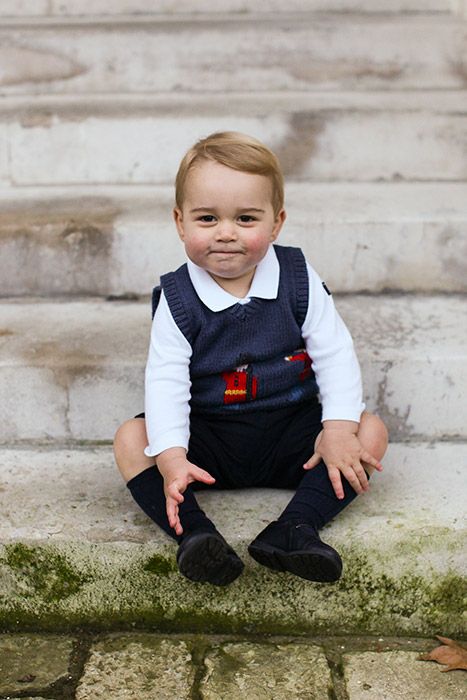 喬治罕見地對著鏡頭微笑。他身穿白襯衫藍背心，雙手嘗試抓住腳... 這張如此正式的照片是在他生日時，凱特王妃為他拍的生日照！