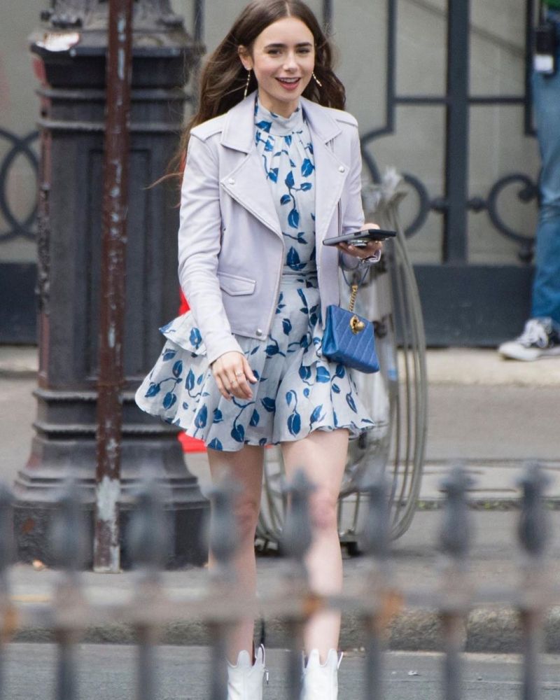 Lily Collins劇中更有一些以花為主的穿搭，十分適合約會時穿著！劇中Lily Collins身穿Aje藍色花連身裙、Vivienne Westwood短靴和Chanel spring 2019同色系手袋，以藍色作主調的搭配十分清新。