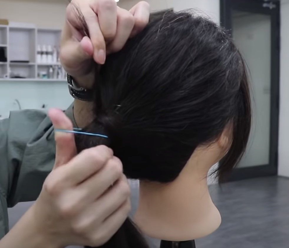 把頭髮完全覆蓋橡筋後，在髮尾的部分留下少少長度