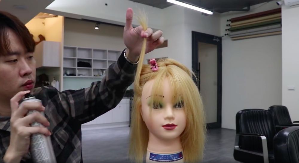 然後把髮際線的部分拉高，然後用定型噴霧，噴向髮根位置 (噴的時候大概與頭髮距離15公分)