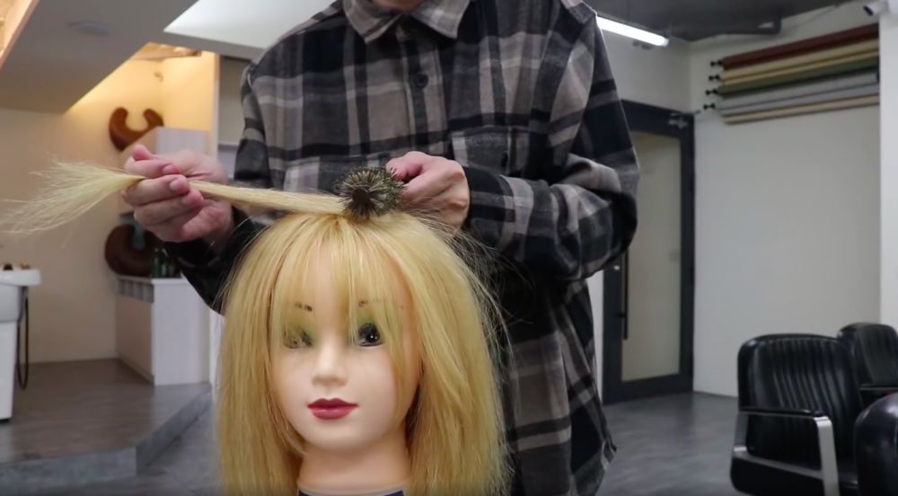 然後再把圓梳放在貼近髮根的位置