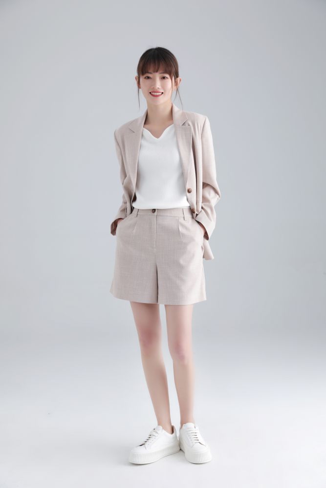  直身輪廓形的西裝外套以輕盈混色面料製成，與高腰短褲同穿，並搭配白色T-Shirt 或針織打底上衣，為女生打造型格的上班造型。