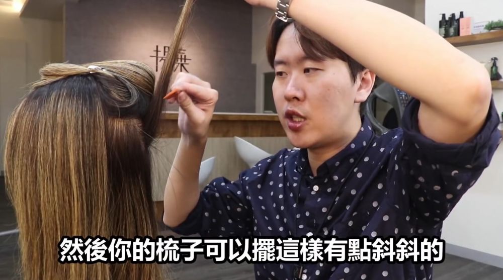 然後把頭髮向上拉起，把梳微微向斜