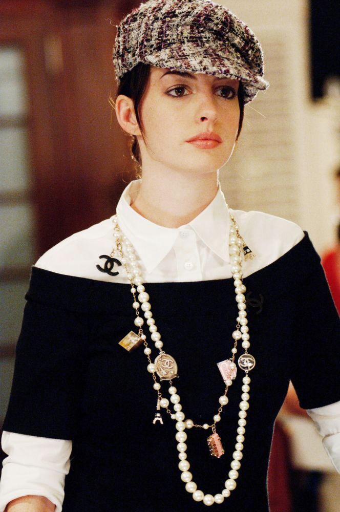 8. Chanel 頸鏈。Anne Hathaway白色恤衫襯黑色一字肩上衣，加上格紋Newsboy Cap（報童帽）和Chanel長頸鏈，簡單而不失層次感。
