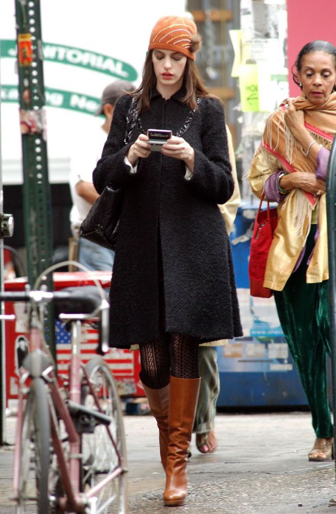 6. Rebecca Taylor長外套。Anne Hathaway身穿黑色長外套，頭戴橙色帽子，和腳上的橙棕色長靴互相點綴，保暖又不失年輕活力的感覺。