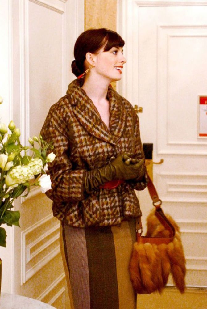 12. 棕色千鳥格上衣。Anne Hathaway身穿棕色千鳥格上衣，配上同色系的裙、皮草手袋，加上紅色的腰帶和紅色的耳環相襯，顏色風格統一。