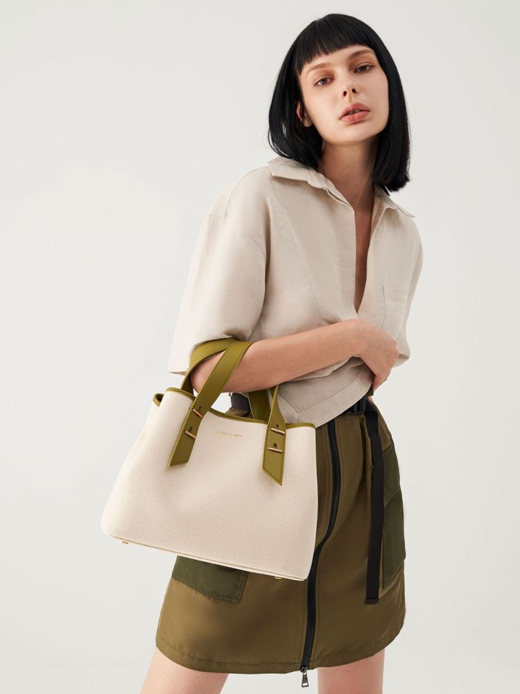 經典磁釦托特包 - 混色 售價HK$769。以酪梨綠色皮帶成為個性點綴，帆布袋身休閑容易配襯。