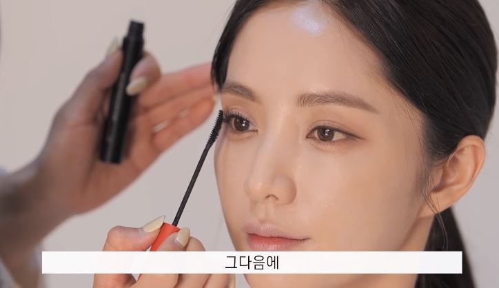 Step2：睫毛膏。Seo Ok示範用睫毛膏刷出假睫毛效果。首先，睜著眼睛在睫毛捲翹位置稍微塗一點。