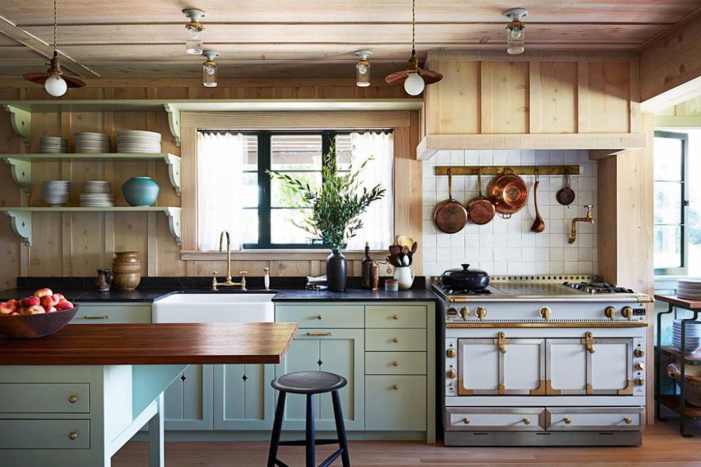 廚房中，將以薄荷綠配上復古銅金色配件，整個空間看起來乾淨又舒適，爐頭挂滿厨具，層架擺滿精美碗碟，看來女神平日也喜歡下厨。（圖片來源：architecturaldigest）