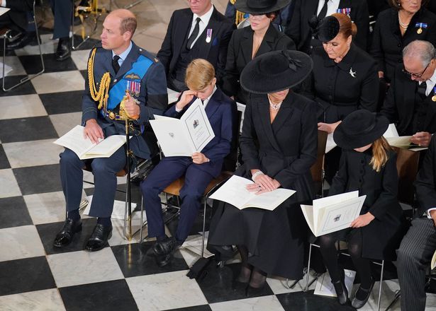 直播片段中，喬治王子坐在爸爸威廉王子與媽媽凱特王妃中間，一度用手偷偷擦拭掉落的淚水。（圖片來源：youtube@royalchannel）