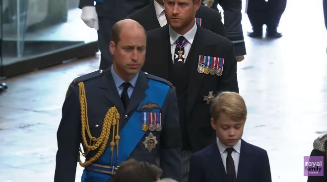 喬治王子緊隨爸爸威廉王子身旁，父子神色凝重。（圖片來源：youtube@royalchannel）
