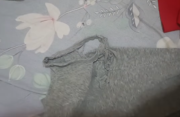 該件灰色的上衣已經有多個小洞，腋下位置更是穿了個大洞，破爛不堪。（Facebook群組「十萬個惡頂老公的惡行」影片截圖）