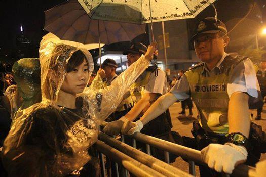 示威者為警員撐雨傘。