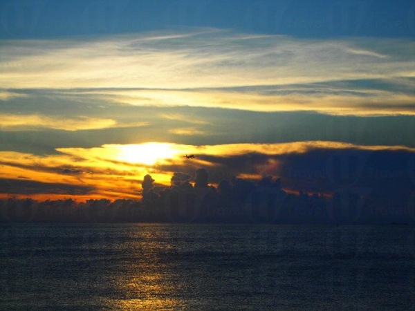 日落為天空和海面添上一抹金黃，襯托遠方的飛機份外迷人。