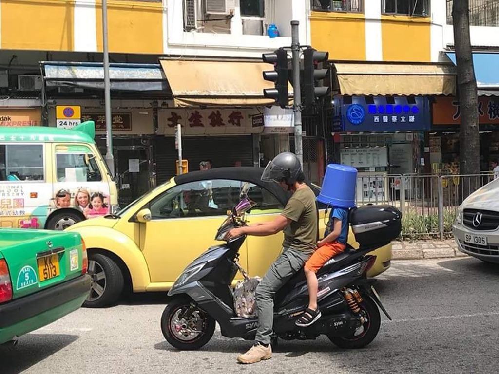 兒童乘電單車用水桶當頭盔？網民：好危險但笑咗