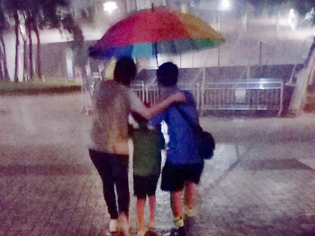 網民激讚！暴雨下少年撐傘來回接送老弱婦孺