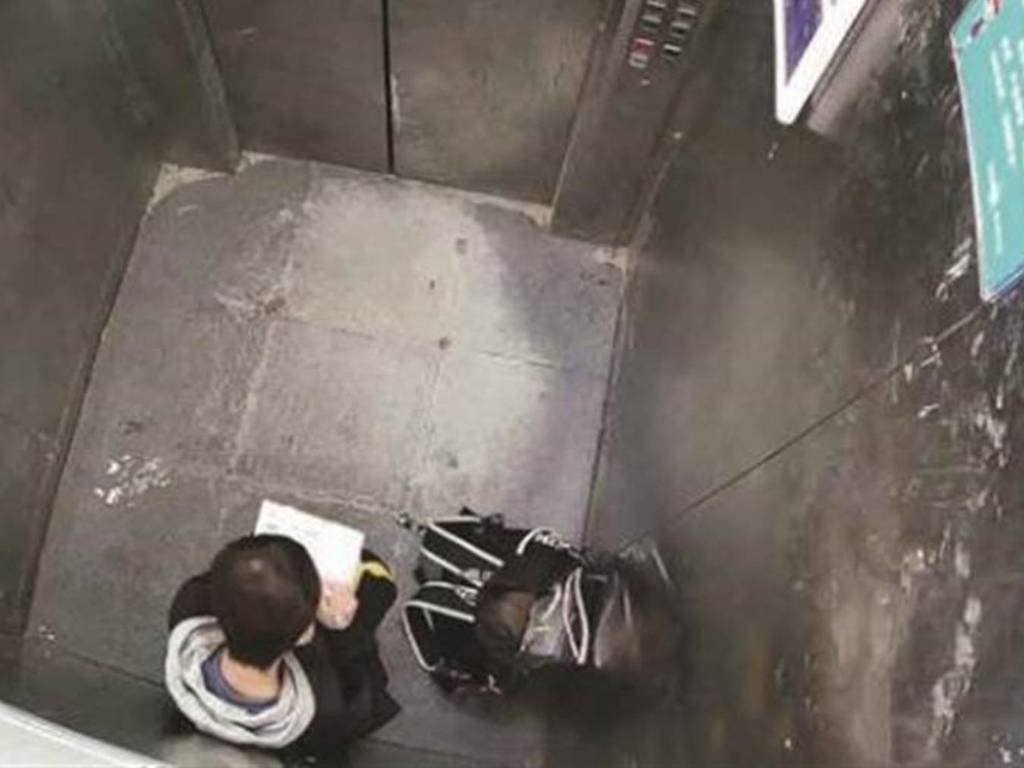 男童遇電梯故障竟蹲下來做功課  淡定態度惹網民熱議