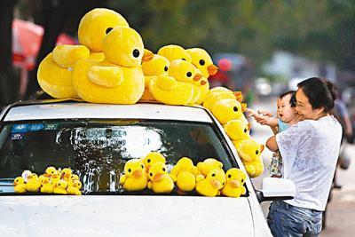 北京街頭四處都見到擺滿黃鴨的私家車擺賣。 黃色巨鴨 9.6游到北京