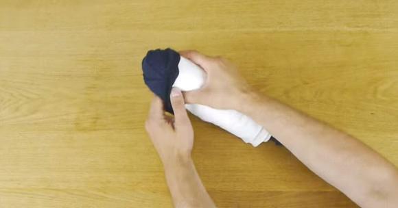 第六步: 把上衣捲到最尾後，用襪子的開口反包著上衣作固定。