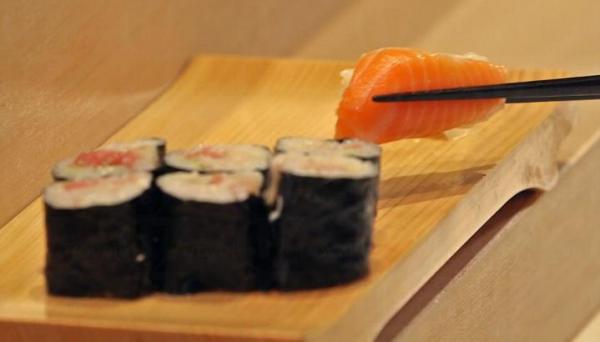 正確的的夾法，是將壽司翻則，筷子夾著三文魚及米飯。(圖：munchies)