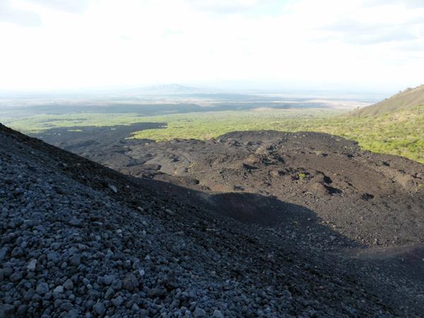 火山附近一片綠油油草原，與火山爆發後形成的黑色礫石形成強烈對比。（圖：sturgischick.files.wordpress.com）