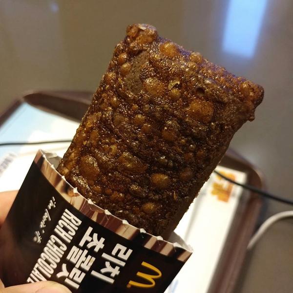 今次韓國麥當勞今日推出的朱古力批強調是「Rich」Chocolate Pie！香港曾經推出的朱古力批外皮和蘋果批一樣是金黃色脆皮，但今次韓國的朱古力批連外皮都加入了朱古力，所以都喺啡黑色，由外到內都好