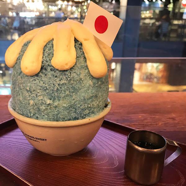 在一層層刨冰上倒上象徵富士山嘅藍色，再用忌廉擠出山頂嘅積雪，最後插上日本國旗，呢個外型同真嘅日本富士山非常相似。﹝圖：teeraphala @ IG﹞