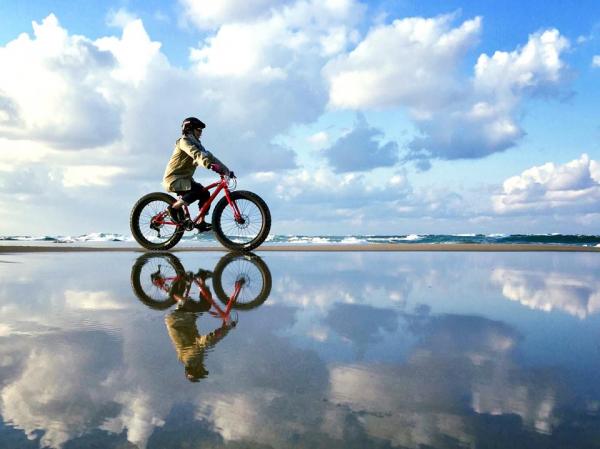 趁潮退時，在海岸線上踩住單車影天空之鏡。 （圖：TRAIL ON＠FB）