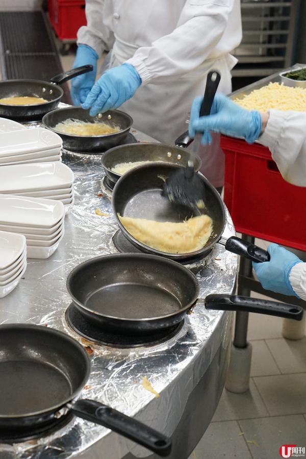一位廚師負責轉動平底鍋、加入餡料，另一位負責翻動和上盒。人手配合機器，每日可以製作 6,000-8,000 份奄列！